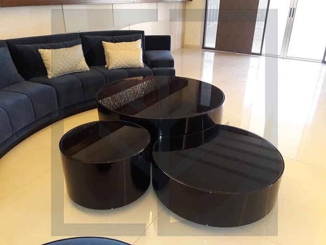 Nesting tables — High-gloss round tables in graduated heights.