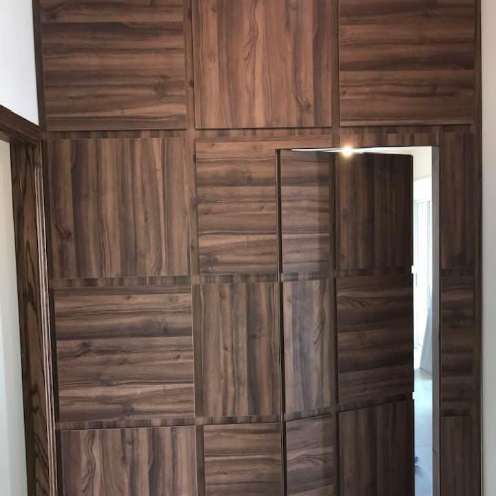 Flush door in panelling — A door concealed in the panel run, its lines continuing across the opening.